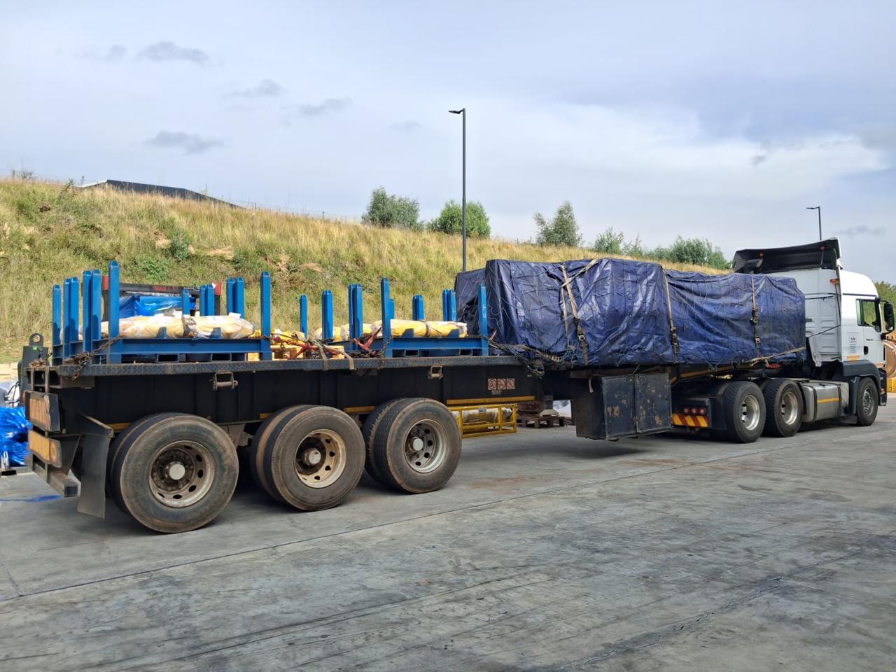 Mcutter Projects flatbed truck carrying tarped cargo